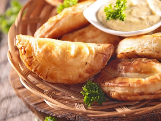 Empanaditas horneadas de masa de maíz rellenas de ricotta, ajo y cebollino